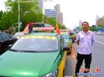 一排愛心送考的士在營(yíng)口市三高門前免費(fèi)送考生